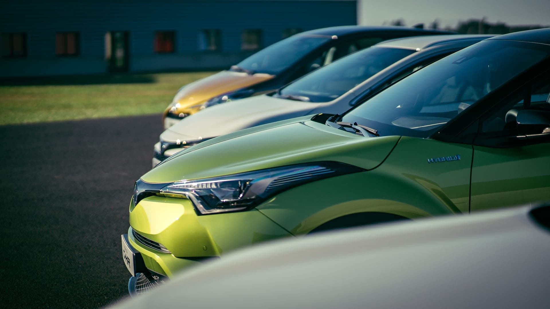 A lime-green Toyota crossover in a row of parked cars