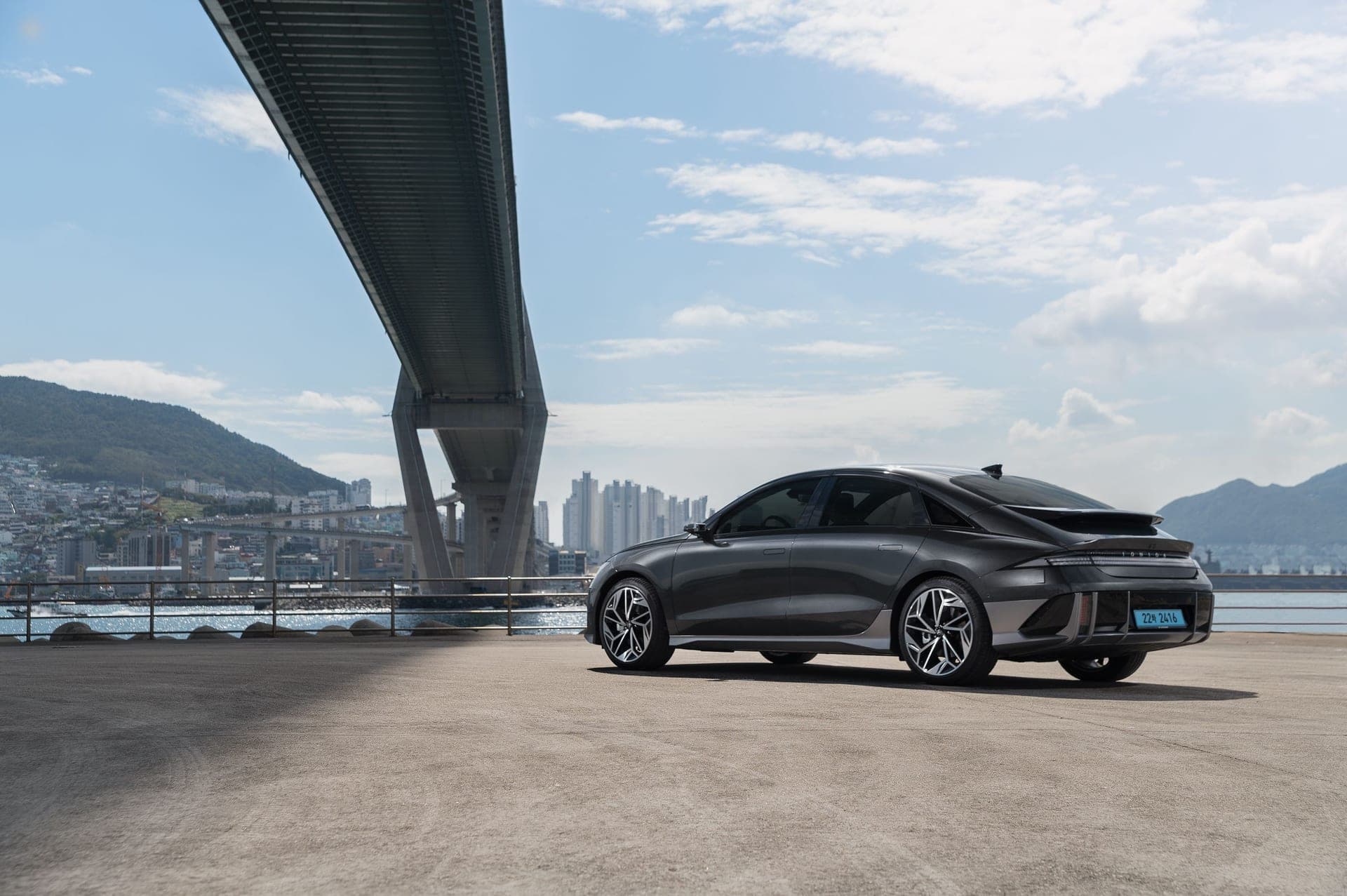 A dark Hyundai Ioniq 6 sedan parked on a waterfront road