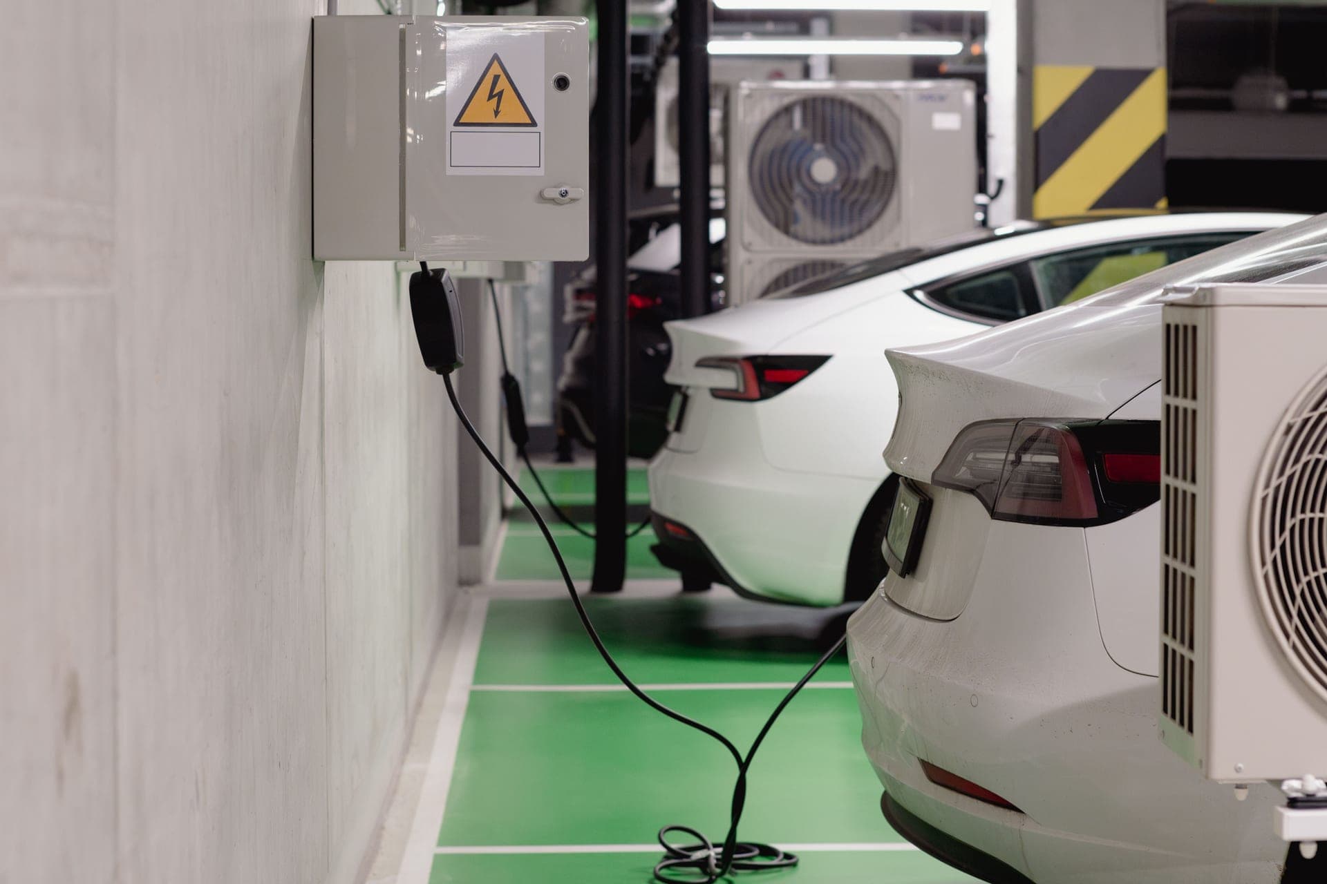 Electric cars charging from wall units in a shared parking garage