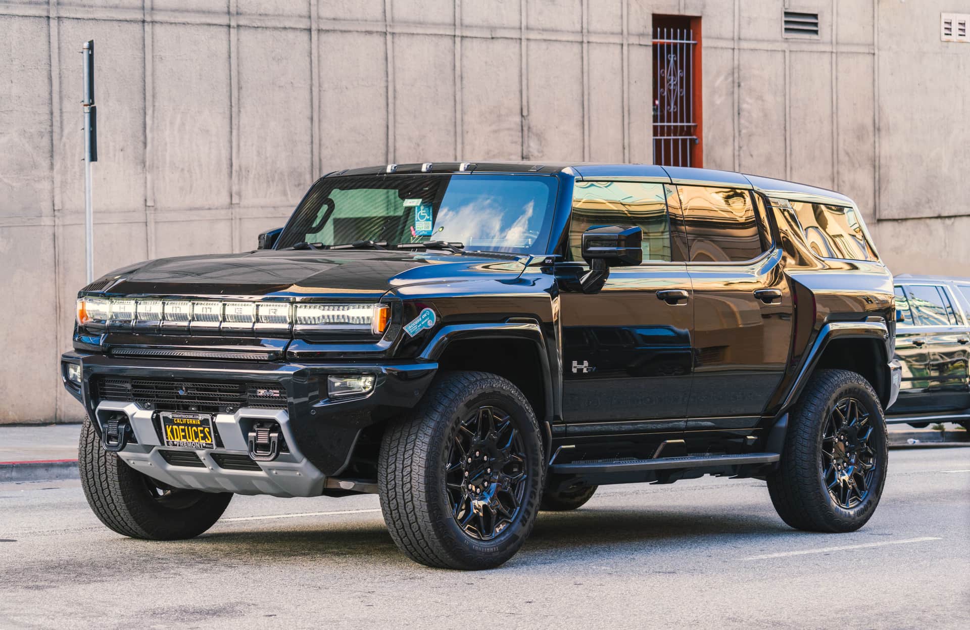 A black GMC Hummer EV SUV parked on a city street