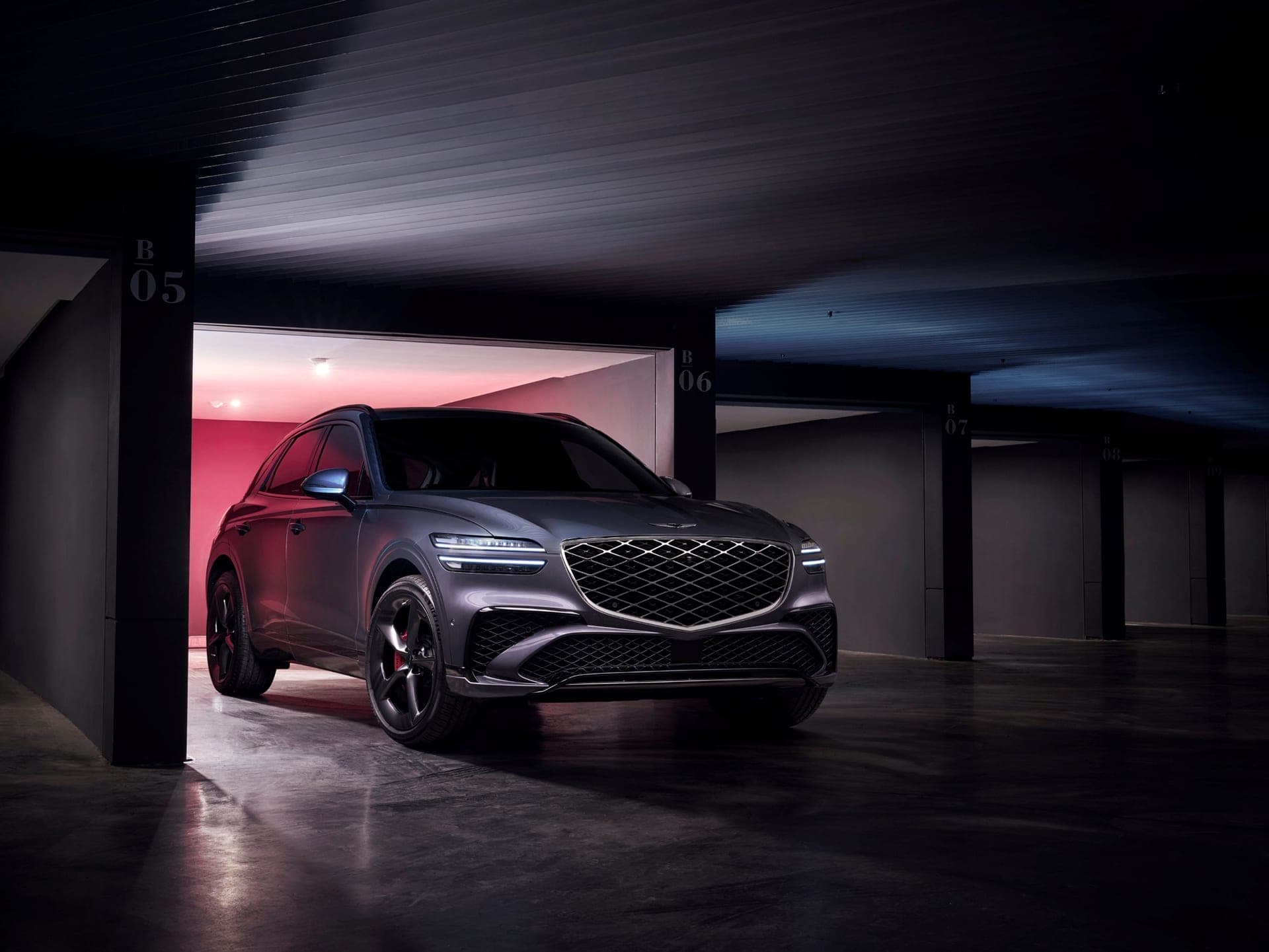 A dark gray Genesis GV70 SUV parked in a garage