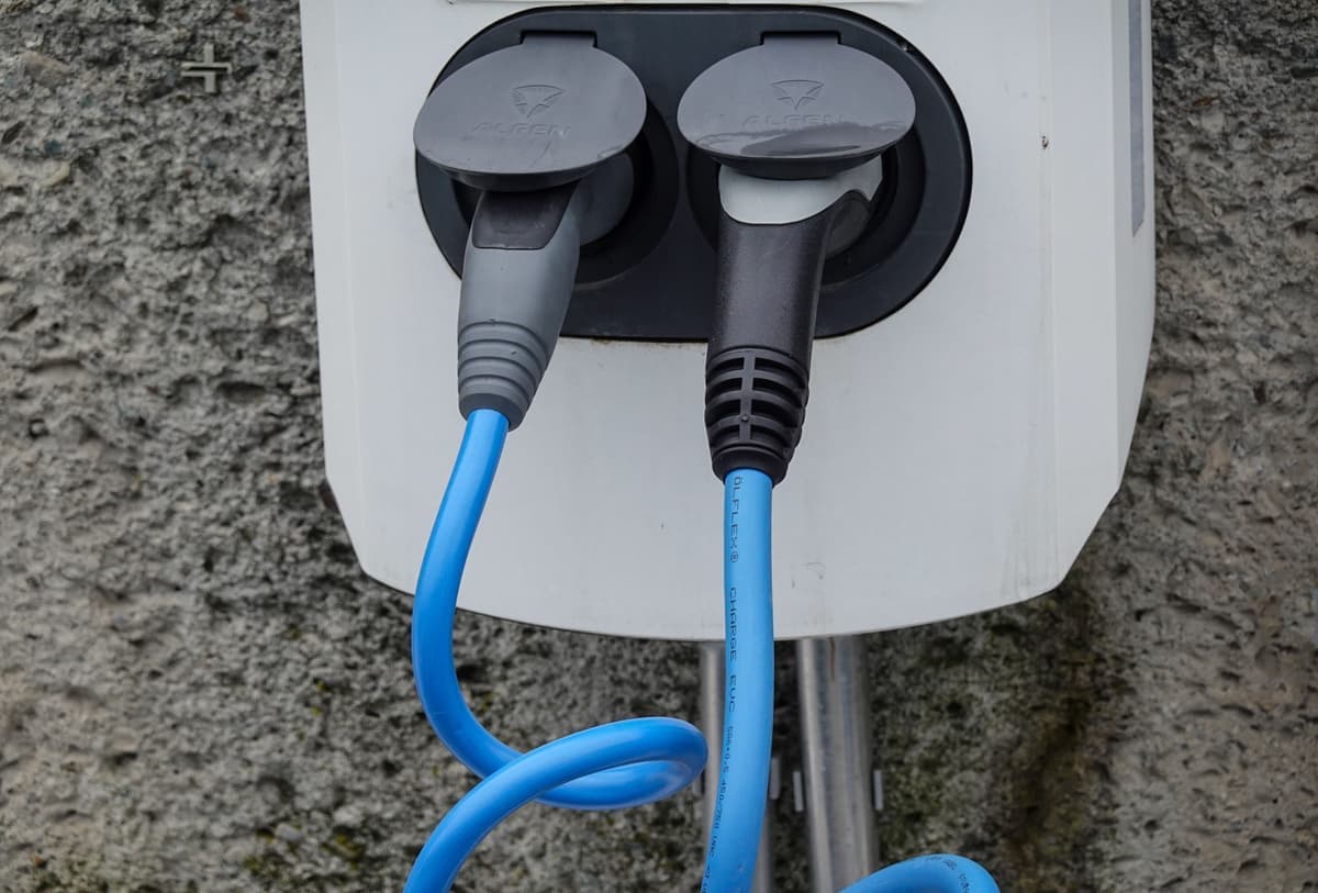 A charging cable coiled neatly beside a wall-mounted charging unit