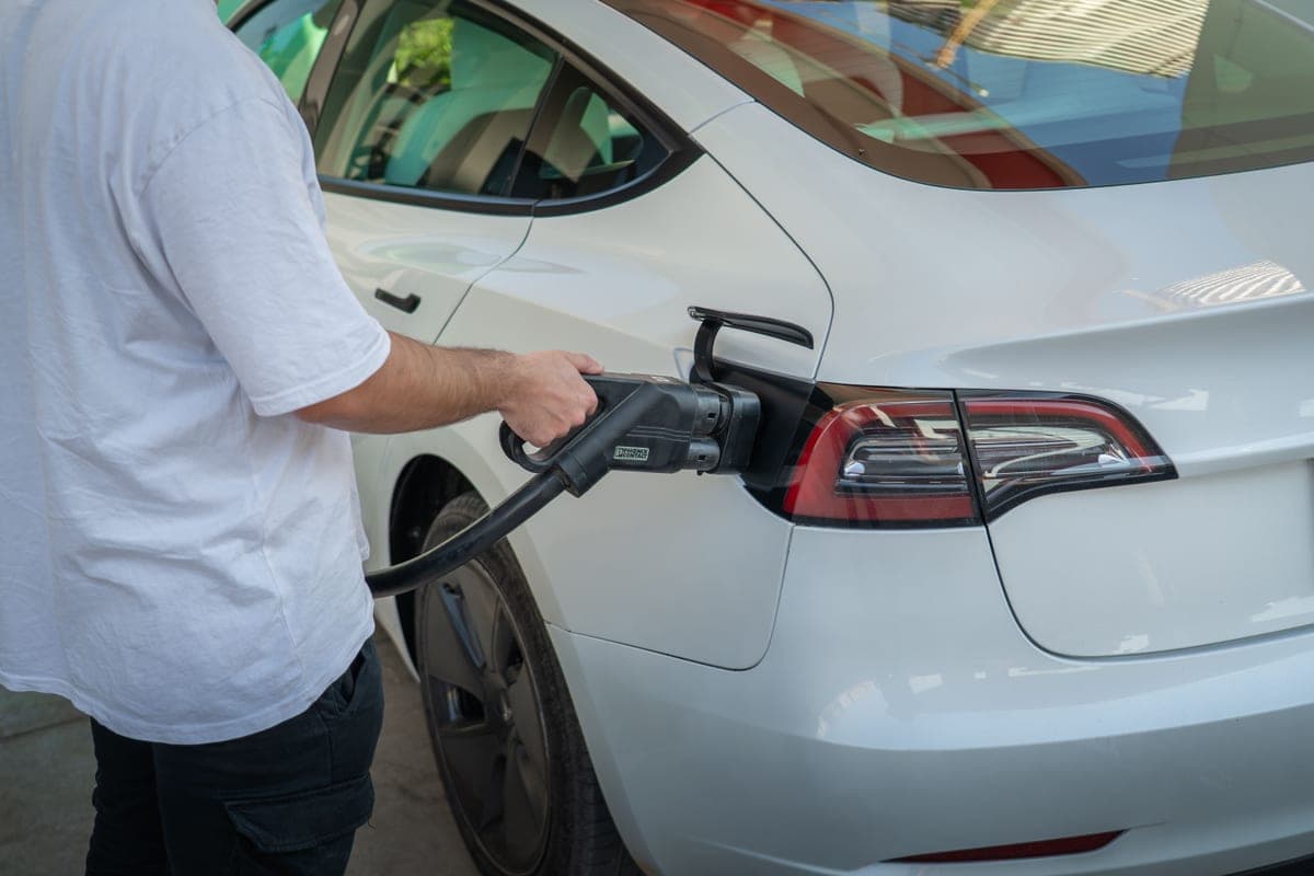 An electric car charging at a home in the evening