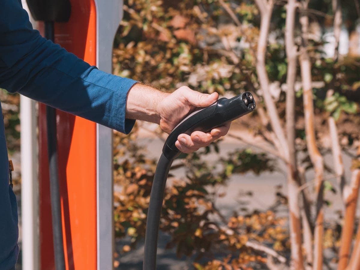 A hand holding an EV charging connector