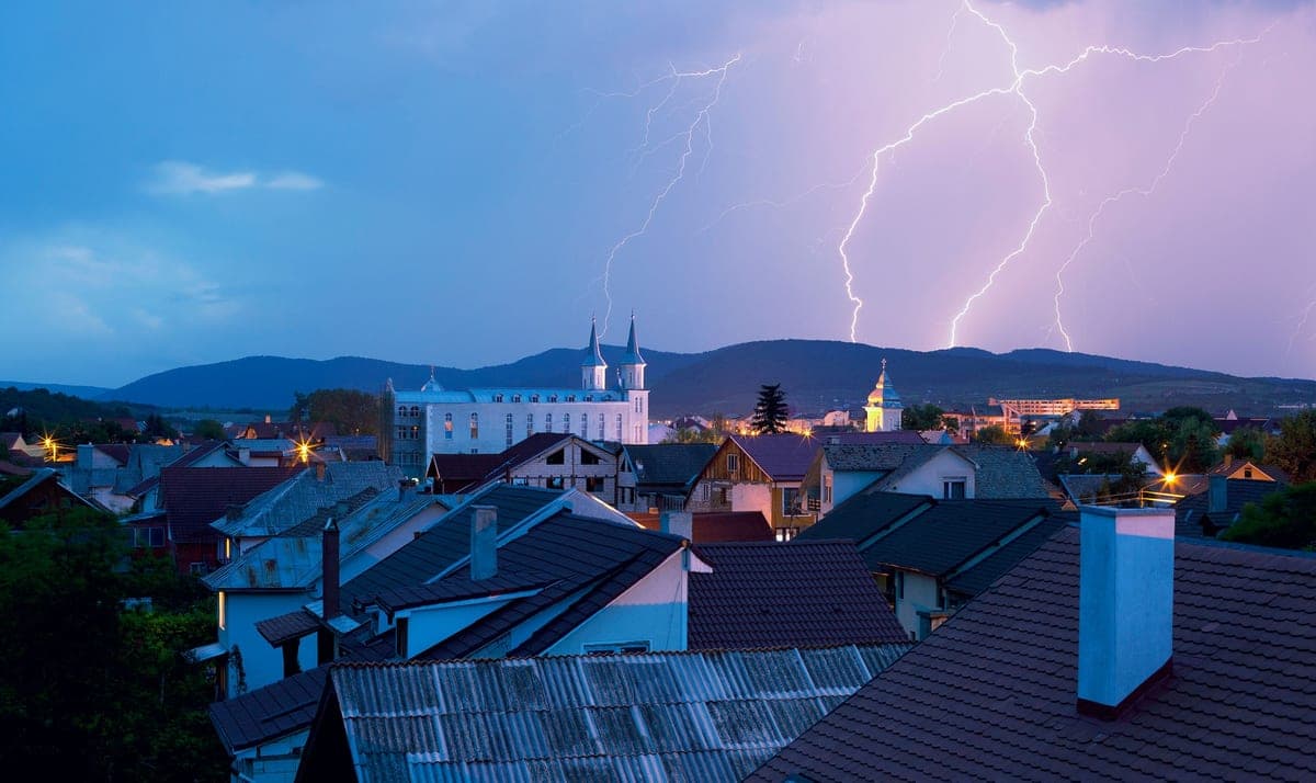 A lightning storm over houses at night
